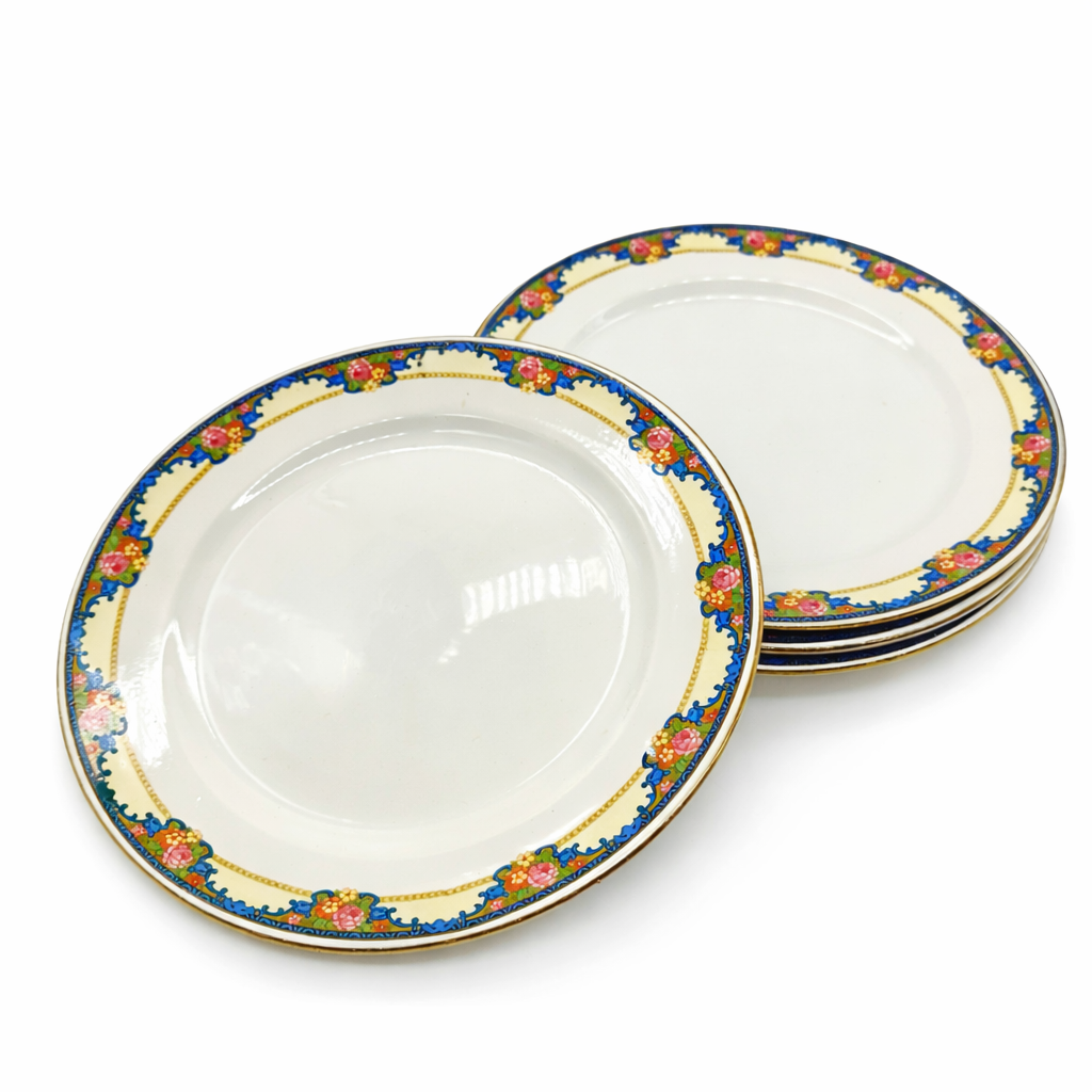 Lot d’assiettes anciennes en faïence à décor floral polychrome, bordure bleue avec motifs floraux et liseré doré, assiettes empilées sur fond blanc