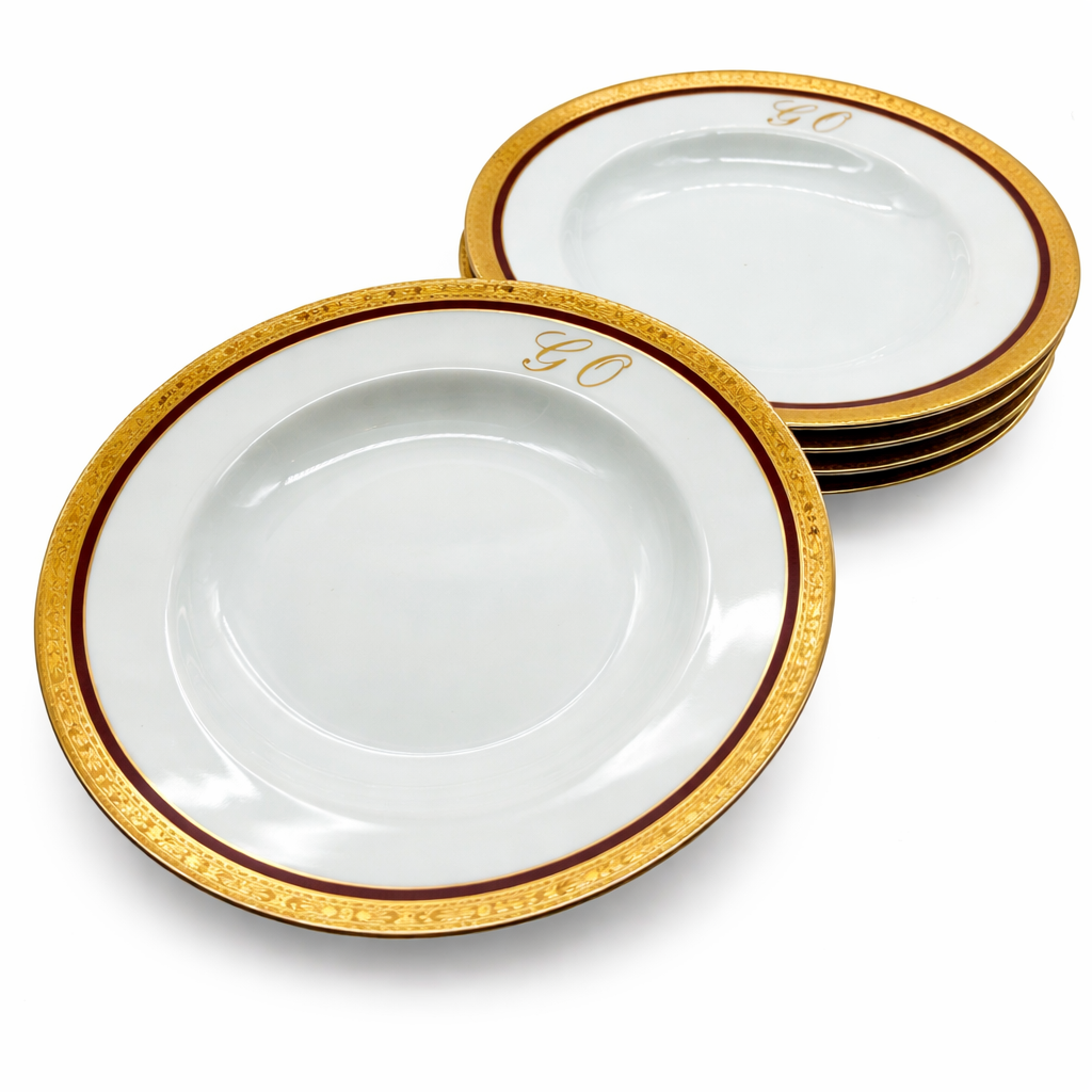 Lot d’assiettes en porcelaine de Limoges décor or et monogramme GO, présentation empilée