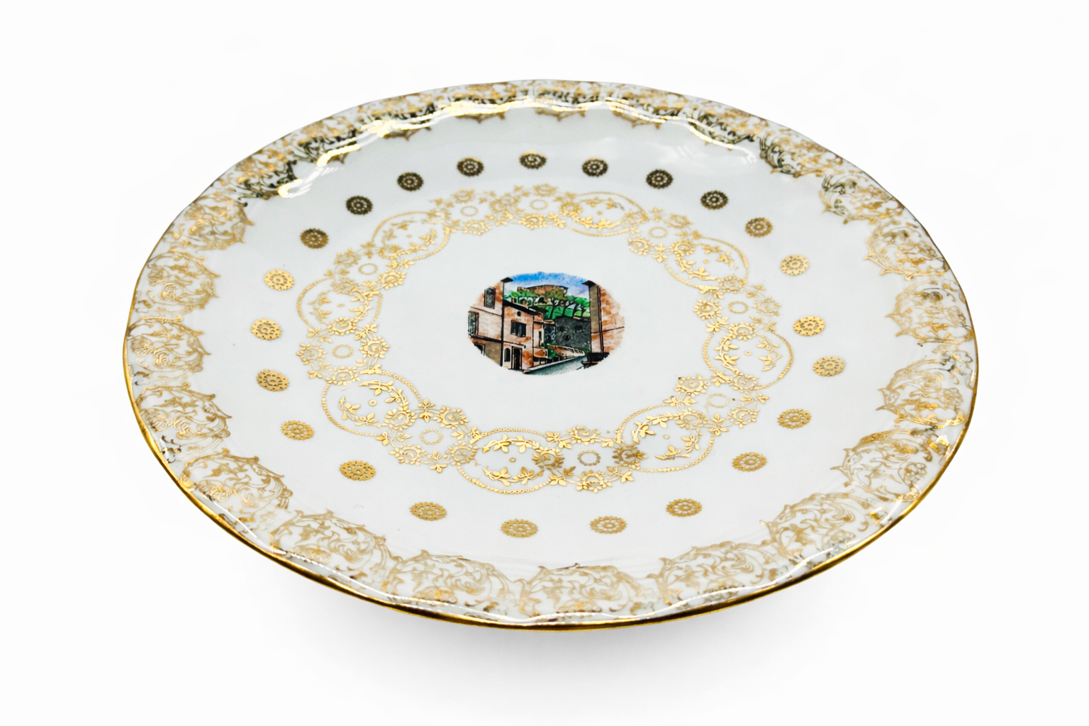 Assiette ancienne en porcelaine de Limoges vue en perspective, décor doré fin et médaillon central architectural, fabrication française