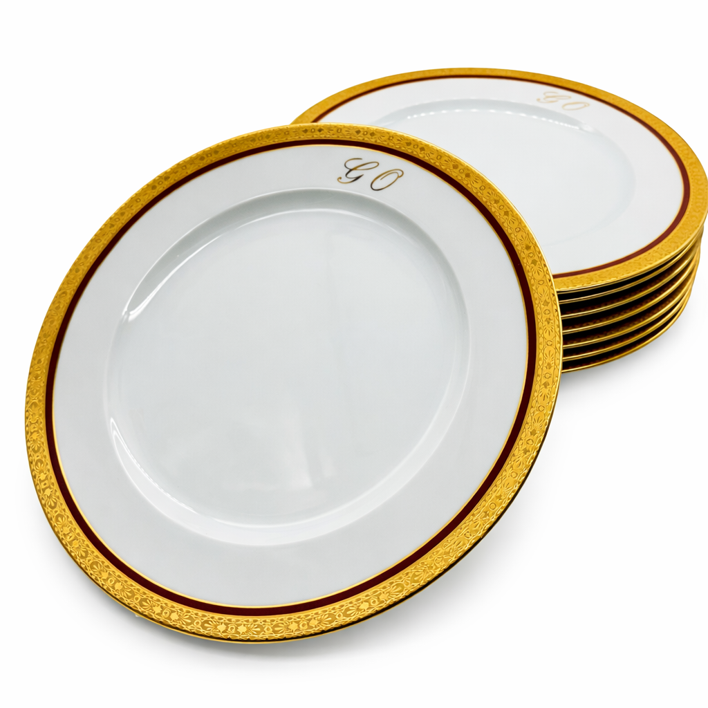 Lot d’assiettes plates en porcelaine de Limoges empilées, décor doré et monogramme « GO »