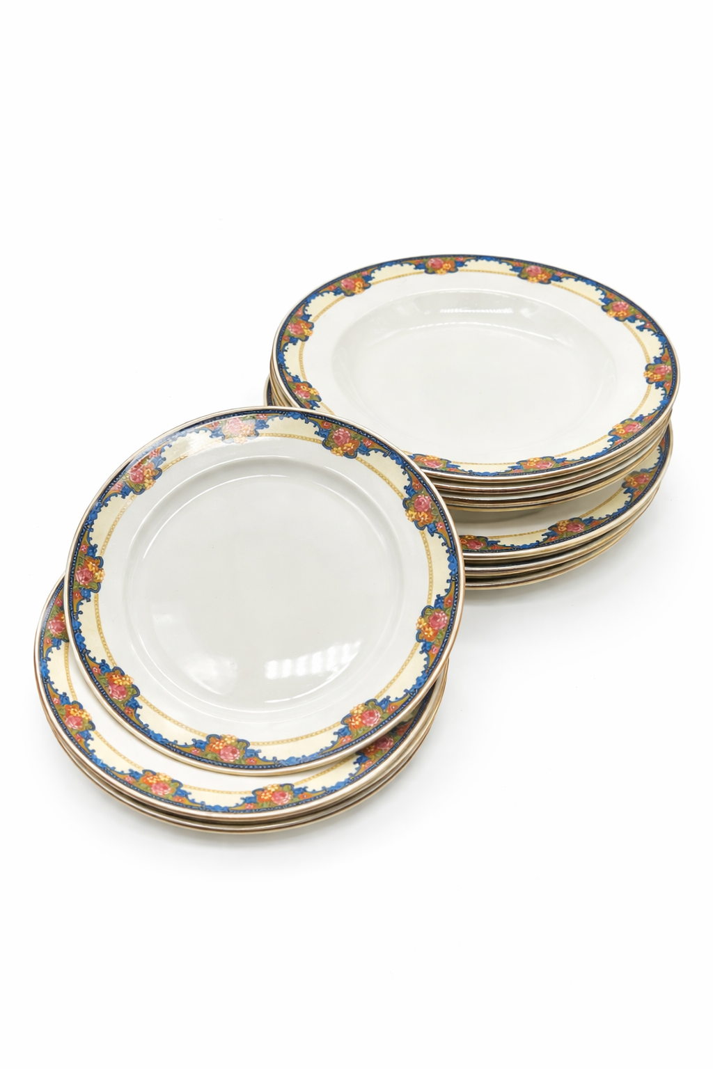 Lot d’assiettes anciennes en faïence à décor floral polychrome, bordure bleue avec motifs floraux et liseré doré, assiettes empilées sur fond blanc