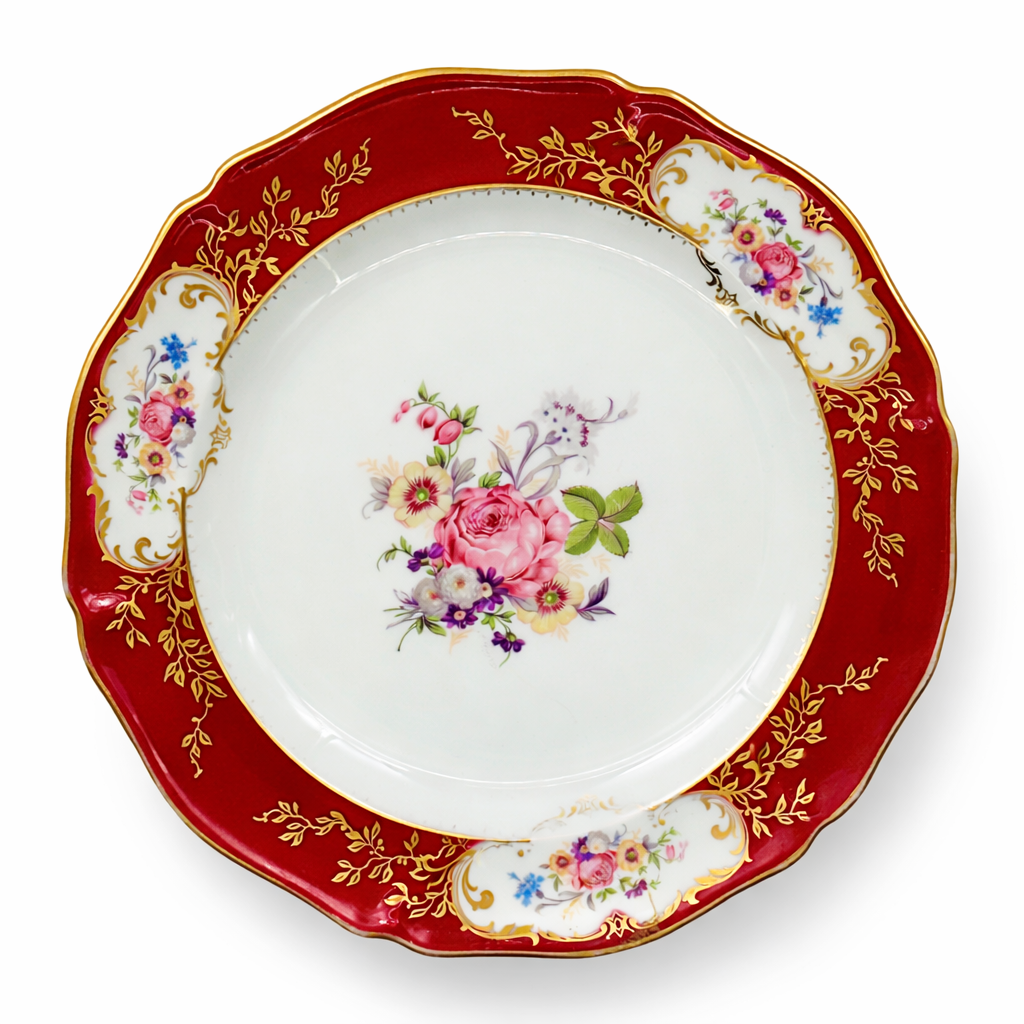Assiette ancienne en porcelaine de Limoges à décor floral polychrome, large aile rouge carmin rehaussée de dorure et bouquet de fleurs central