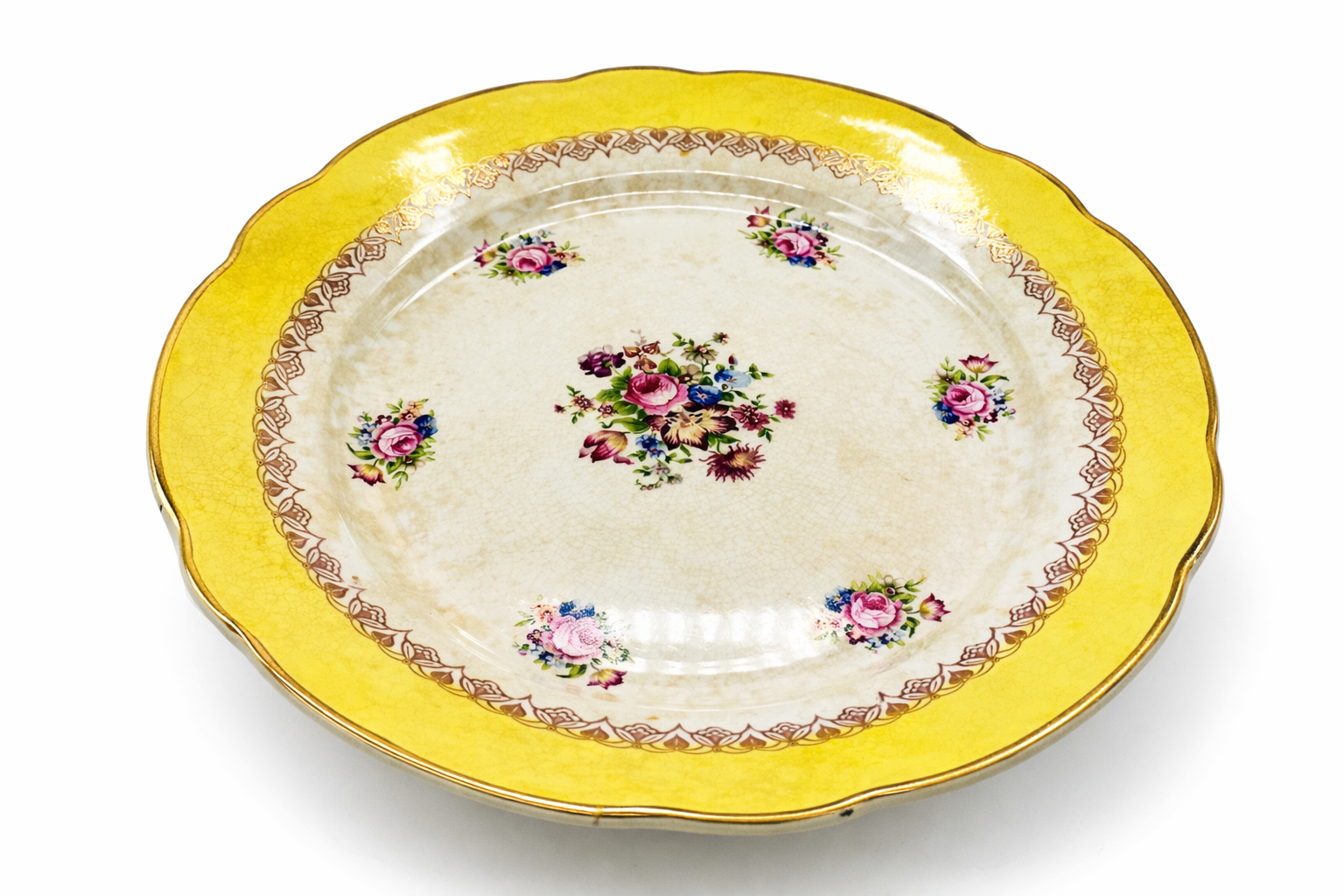 Assiette vintage en porcelaine à aile jaune dorée, fleurs anciennes peintes, vue de dessus décalée