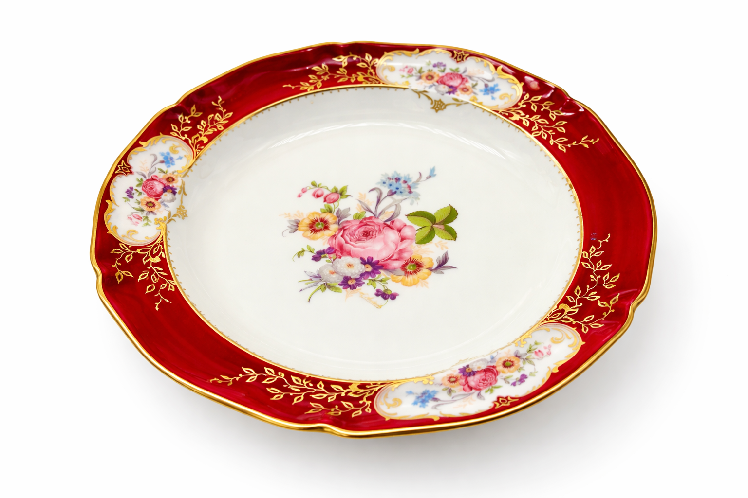 Assiette creuse  ancienne en porcelaine de Limoges vue en perspective, décor floral central et bordure rouge et or finement travaillés