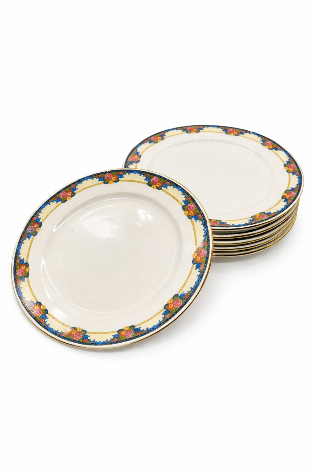 Lot d’assiettes anciennes en faïence à décor floral polychrome, bordure bleue avec motifs floraux et liseré doré, assiettes empilées sur fond blanc