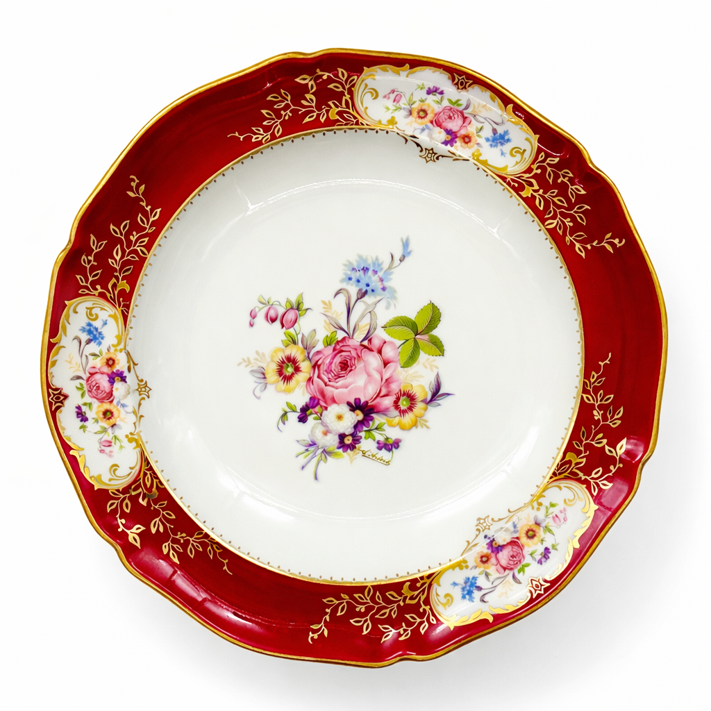 Assiette creuse ancienne en porcelaine de Limoges à décor floral polychrome, large aile rouge carmin rehaussée de dorure et bouquet de fleurs central